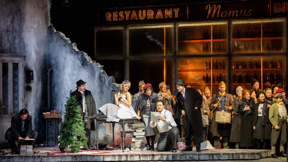 LA BOHÈME Oper von Giacomo Puccini / Wiederaufnahme

Opernhaus



„Scènes de la vie de Bohème“ von Henri Murger in vier Bildern, Text Giuseppe Giacosa und Luigi Illica

In italienischer Sprache mit deutschen Übertiteln



TEAM

Musikalische Leitung: Lutz de Veer

Regie/Bühne/Kostüme: Alexandra Szemerédy, Magdolna Parditka

Licht: Karl Wiedemann

Chor: Tarmo Vaask

Dramaturgie: Wiebke Hetmanek



BESETZUNG

Christian Reuter: Musikalische Leitung

Mimì: Emily Newton

Musetta: Andromahi Raptis

Rodolfo: Arthur Espiritu

Marcello: Sangmin Lee

Schaunard: Wonyong Kang

Colline: Nicolai Karnolsky

Alcindoro: Dariusz Siedlik

Benoît: Suren Manukyan

Parpignol: Klaus Brummer

Sergeant: Moon Shick Oh

Zöllner: Gor Harutyunyan

Orchester: Staatsphilharmonie Nürnberg

Chor: Opernchor

Kinderchor: Jugendchor des Lehrergesangvereins Nürnberg



BESCHREIBUNG

Die Bohemiens feiern, lachen, frieren zusammen und sind auf der Suche nach der einzig wahren Kunst. Das wahre Leben bricht in Gestalt der schwindsüchtigen Mimì in die fröhliche Männer-WG. Ihr Tod öffnet Rodolfo den Blick für die Wirklichkeit – und inspirierte Puccini zu seiner wohl bekanntesten Oper.



Vielleicht war es die Erinnerung an seine eigenen Bohème-Jahre, die Puccini zu den 1851 erschienenen „Szenen aus dem Leben der Bohème“ von Henri Murger zog. Der Roman besteht aus einer lockeren Folge von Episoden, Genreszenen und Gestalten aus dem Pariser Bohème-Milieu, dessen Zentrum vier junge Künstler bilden. Auch Puccini stellt sie in den Mittelpunkt seiner Oper: Den Maler Marcello, den Dichter Rodolfo, den Philosophen Colline und den Musiker Schaunard. Sie leben in einer Art WG zusammen und erproben, ob sie tatsächlich zum Künstler taugen. 



So zumindest definiert Murger den „Zustand Bohème“: „Die Bohème ist die Vorstufe des Künstlerlebens, sie ist die Vorrede zur Akademie, zum Hospital oder zum Leichenschauhaus.“ Diese Definition übernehmen die beiden ungarischen Regisseur